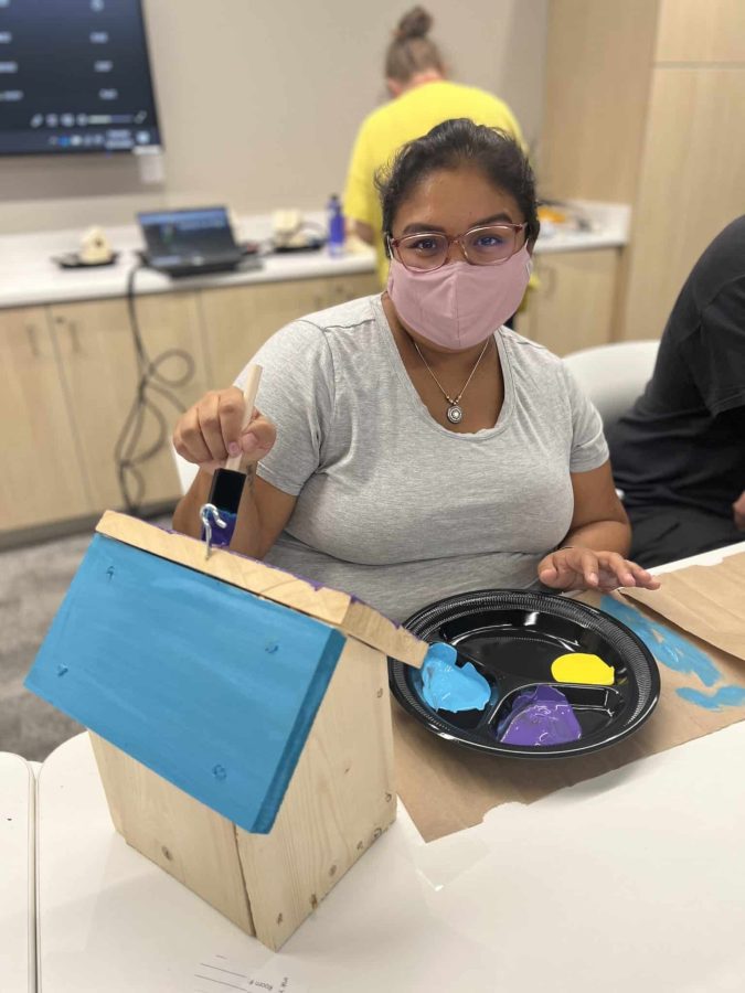 Image from Moments of Joy - Woman painting a miniature house